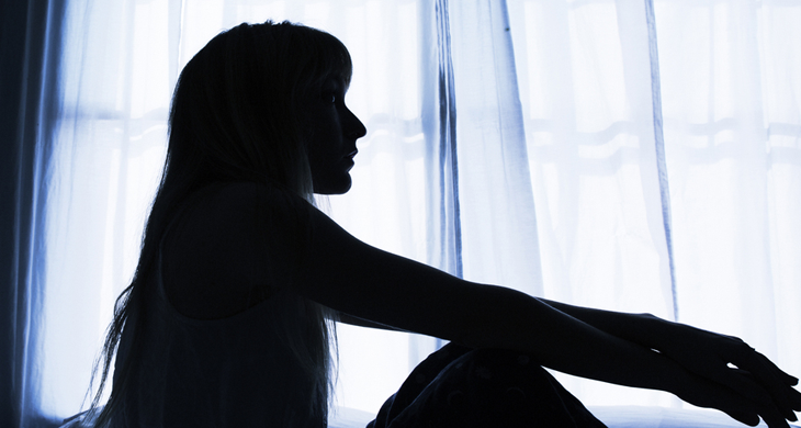 部屋で悩む女性