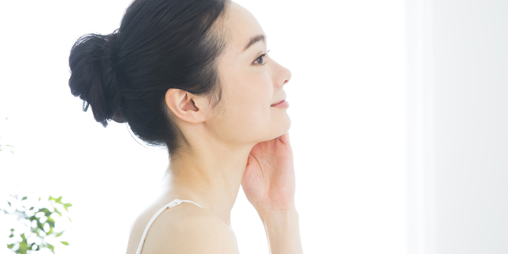 肌をさわって笑顔な女性