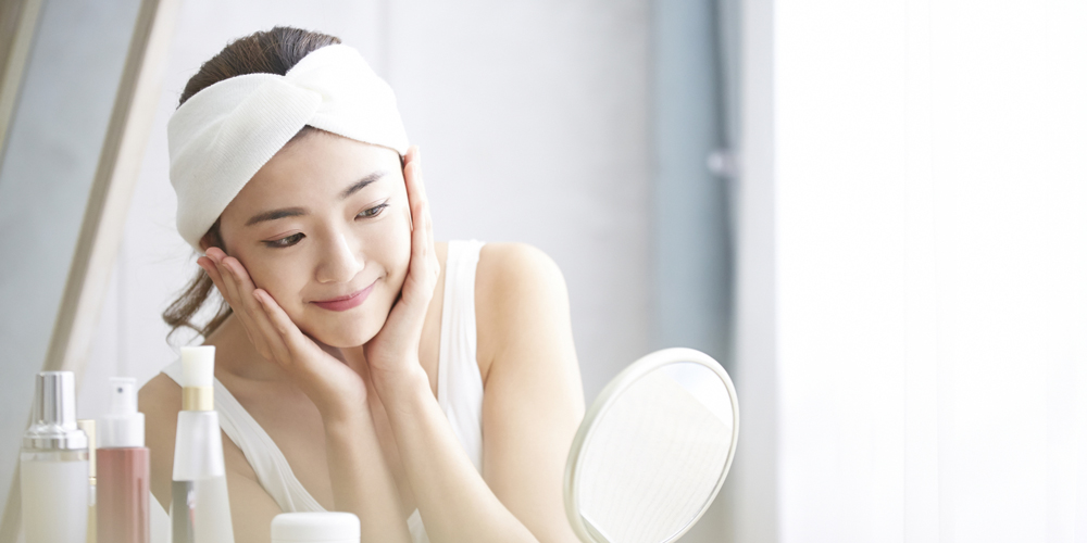 白い部屋でスキンケア中の女性